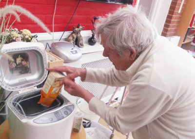 Resident pouring ingredients into a bread maker
