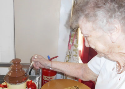 Woodstock lady dipping a strawberry into a chocolate fountain