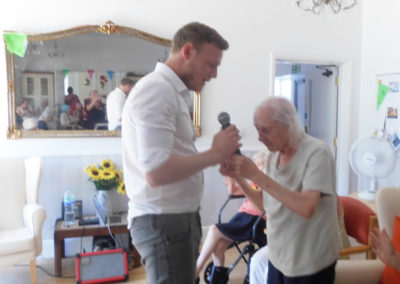 Curtis Skinner singing and holding hands with a resident at Woodstock