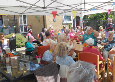 Woodstock Residential Care Home residents and family members sat outside singing and dancing in their chairs to an Elvis singer