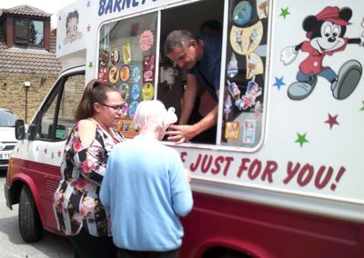 Staff and resident buying ice-cream from a van