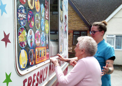 Resident and staff member at the counter of an ice-cream van, deciding what to have