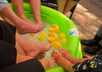 Close up of feet in a pool with rubber ducks