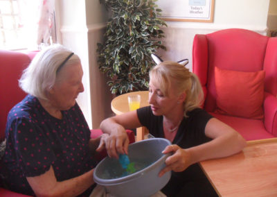 Staff and resident with a bowl of magic sand and water