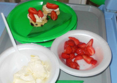 Plates of scones, cream and fresh strawberries