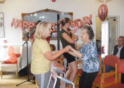 Residents and relatives dancing in the lounge at Woodstock Residential Care Home