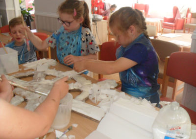 Children making a pirate ship wheel with residents at Woodstock