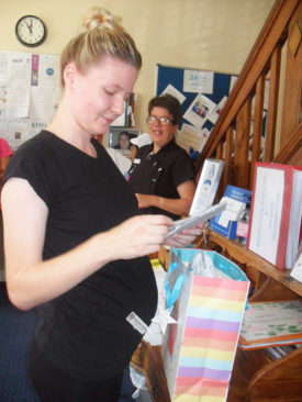 Staff member opening maternity gifts from her colleagues