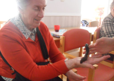 A resident with a giant millipede on her hand at Woodstock Residential Care Home
