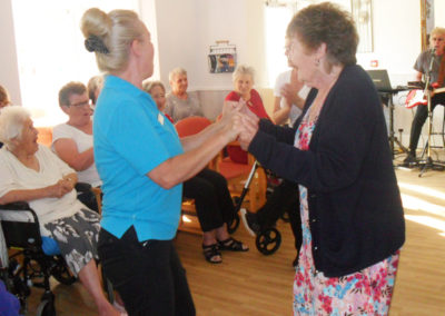 Staff member and resident dancing together in the lounge