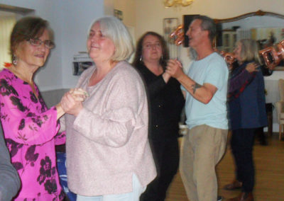 Relatives dancing in the lounge together at Woodstock Residential Care Home