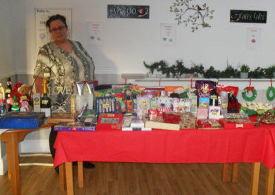 Lady standing at a Tombola table, filled with prizes