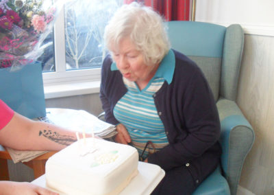 Woodstock resident blowing out the candles on her iced birthday cake