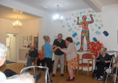 Staff and residents dancing in the lounge at Woodstock
