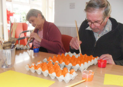 Residents at Woodstock painting an egg box for St David's Day crafts