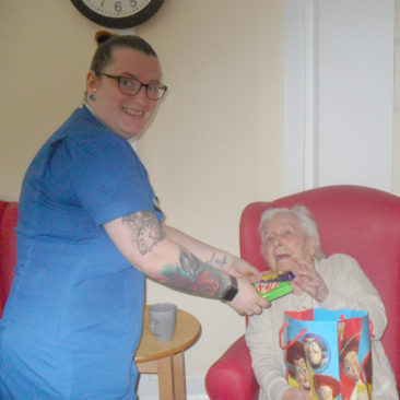 Woodstock Residential Care Home staff member receiving sweets from a resident