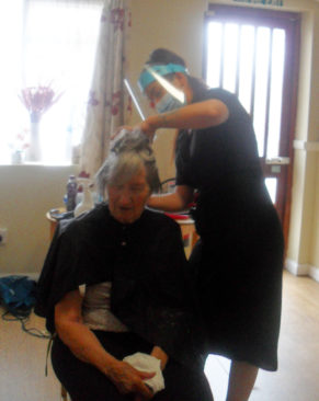 Hairdresser cutting a resident's hair at Woodstock Residential Care Home