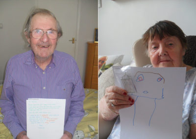 Residents with drawings from nursery school pen pals