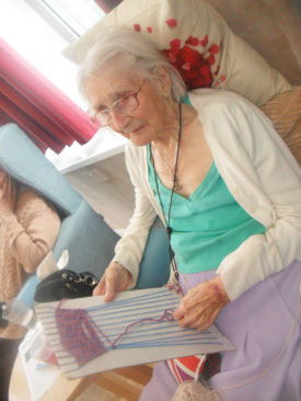 Woodstock Residential Care Home resident doing some weaving on a card board 
