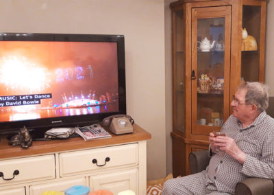 Woodstock Residential Care Home resident watching New Year fireworks on television