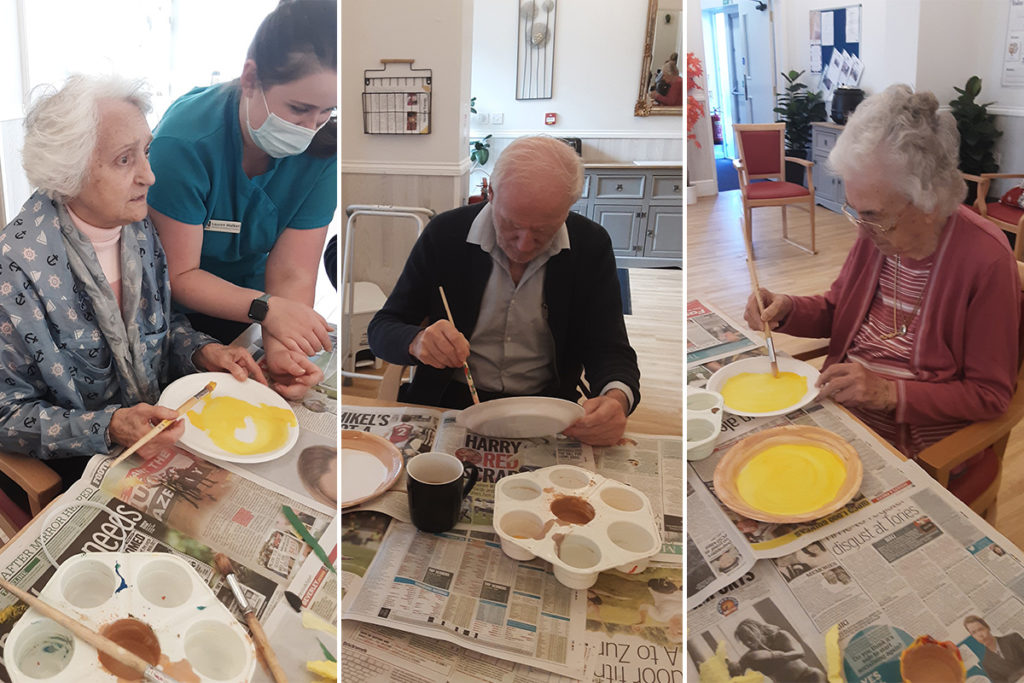 Residents painting plates to make pizza hats at Woodstock Residential Care Home