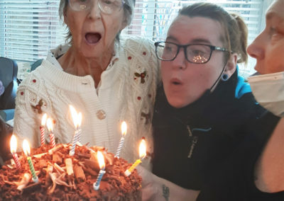 Resident leaving party with cake at Woodstock Residential Care Home