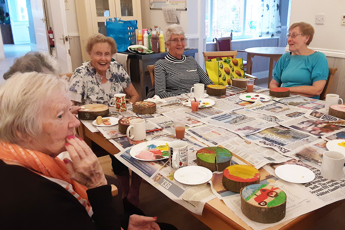 Woodstock Residential Care Home residents enjoying painting autumn pictures on log pieces