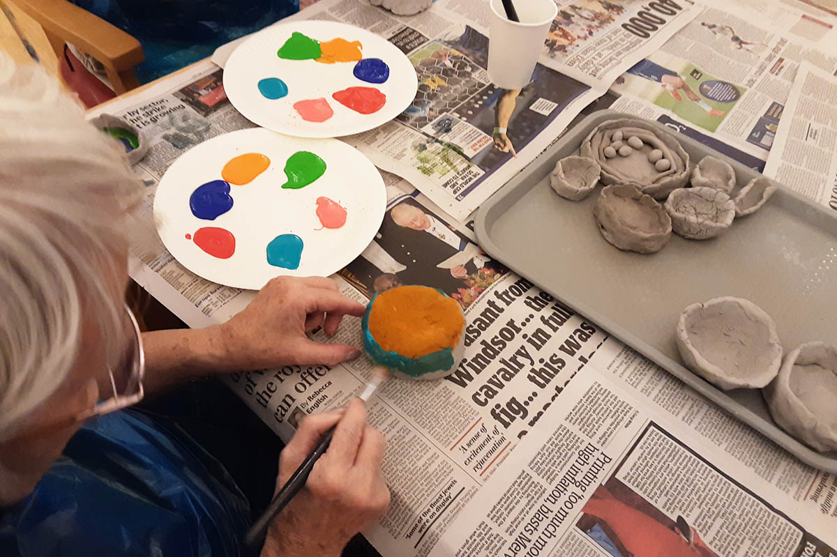 Painting clay Diwali pots at Woodstock Residential Care Home