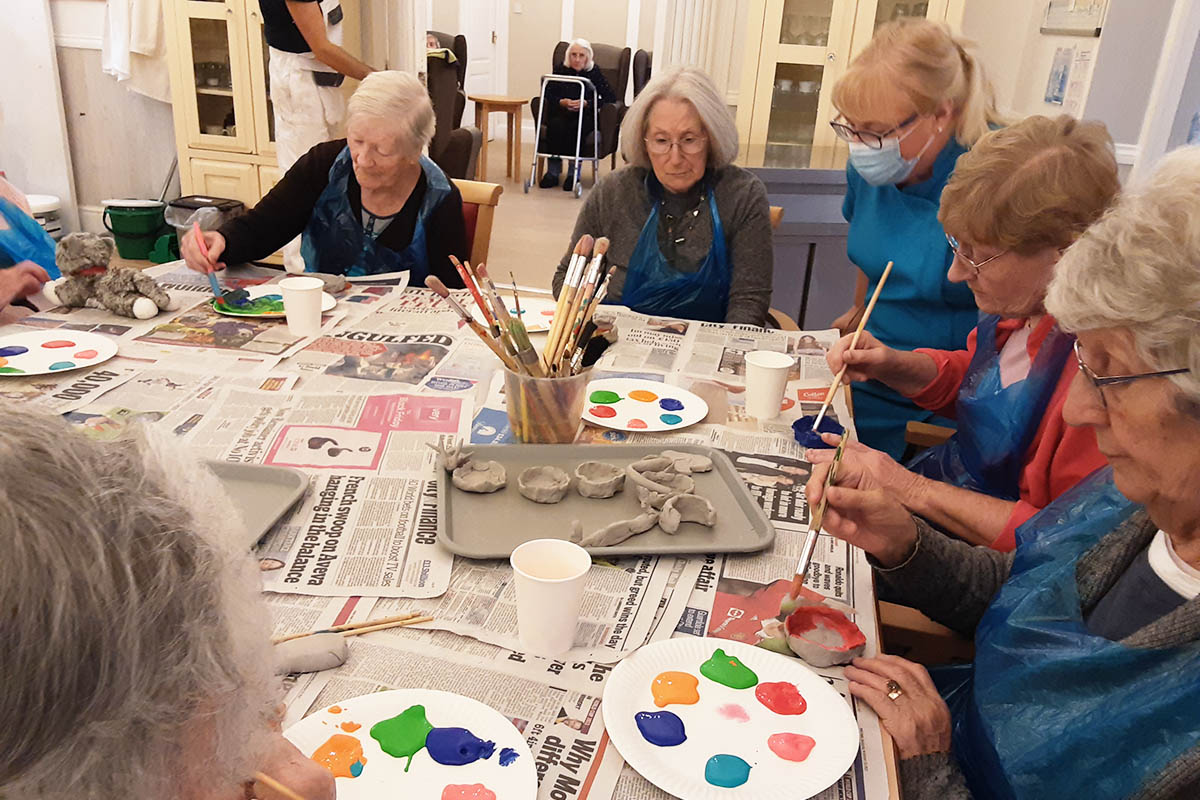 Painting clay Diwali pots together at Woodstock Residential Care Home